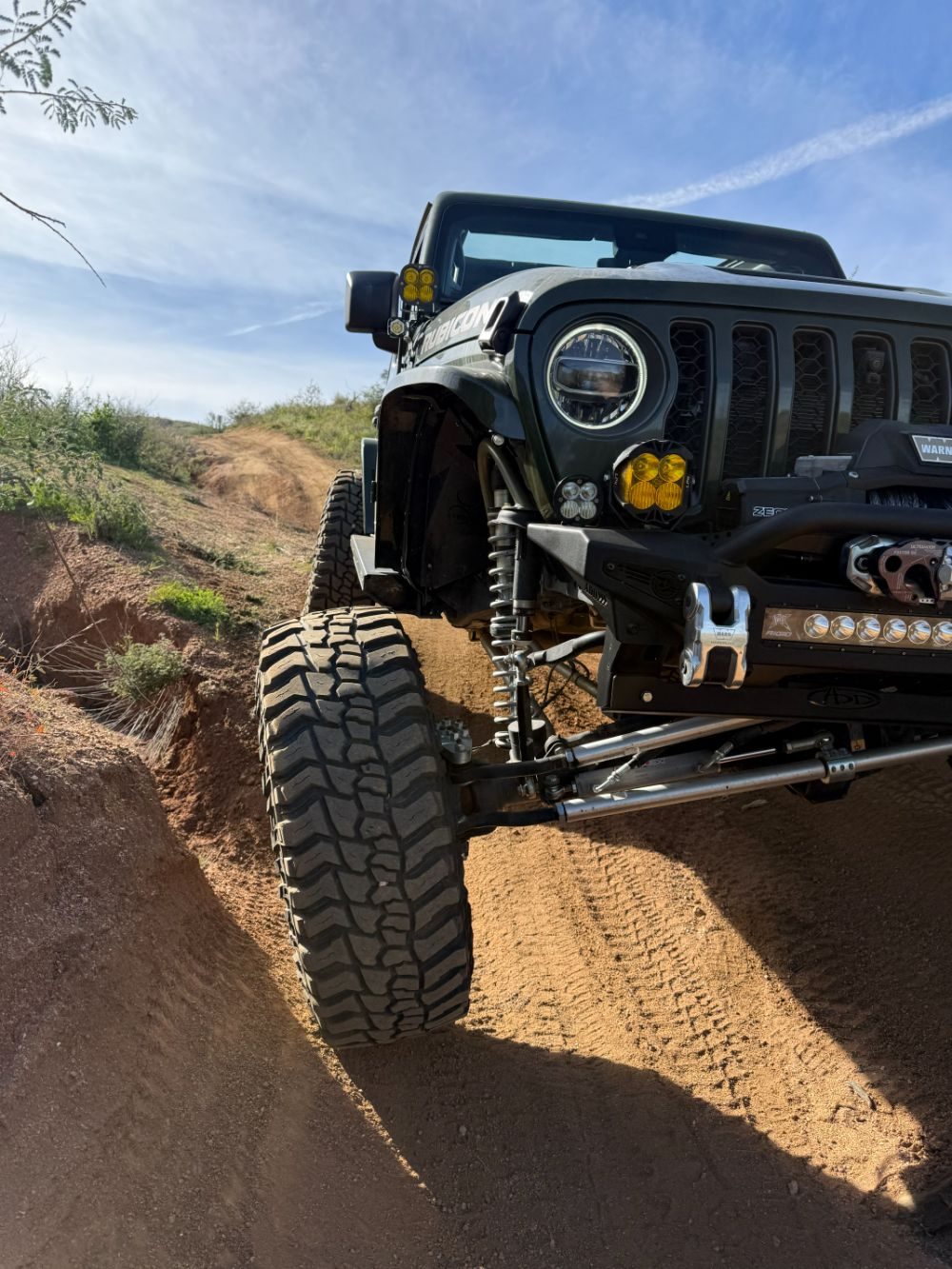Lifted green Jeep Wrangler Rubicon on an Arizona trail