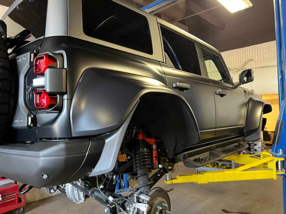 Matte gray Ford Bronco build on the lift at Outlaw